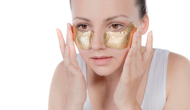 Portrait Of Sexy Healthy Girl Removing, Peeling Cosmetic Gold Mask From Beautiful Face Skin