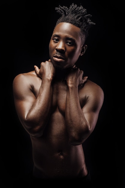 Portrait of sexy naked African-American man on black background