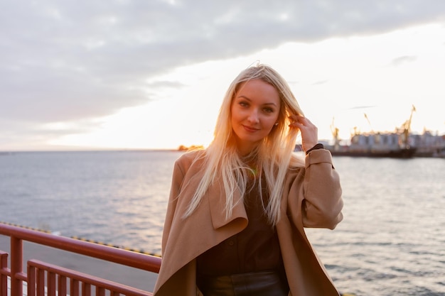 Portrait of sexy stylish blonde woman at sunrise on the beach