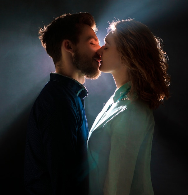 Portrait of a sexy young couple in pre kiss with streams of light