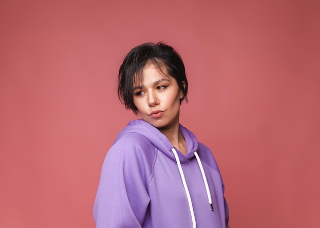 Portrait she is a pretty attractive cute cute charming cheerful cheerful girl with short black hair isolated on a pink pastel background Studio portrait