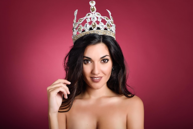 Photo portrait of shirtless beautiful model wearing crown against red background