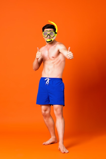 Portrait of a shirtless caucasian man wearing snorkel doing thumbs up gesture