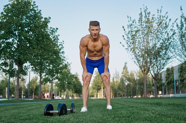 Photo portrait of shirtless man exercising on field