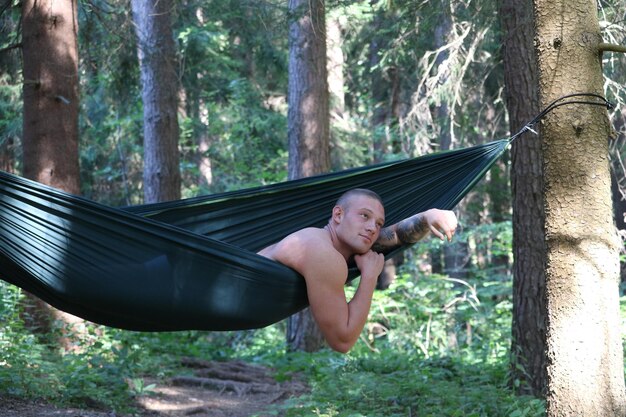 Foto ritratto di un uomo senza camicia nella foresta