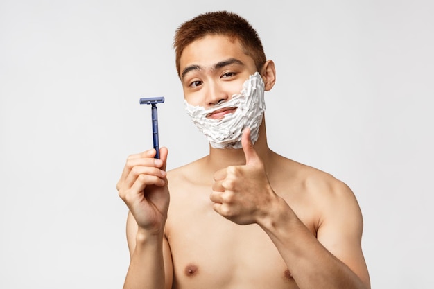 Photo portrait of shirtless man standing against white background