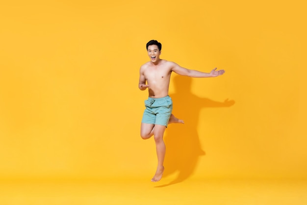 黄色い背景に立っているシャツのない男の肖像画