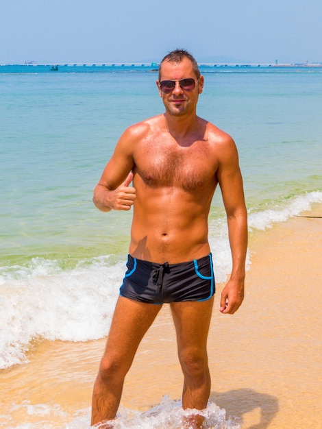 Portrait of shirtless man standing on beach