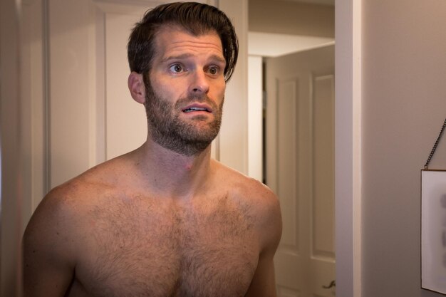 Photo portrait of shirtless man standing at home