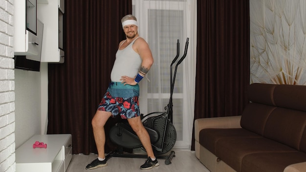 Photo portrait of shirtless man standing on sofa at home