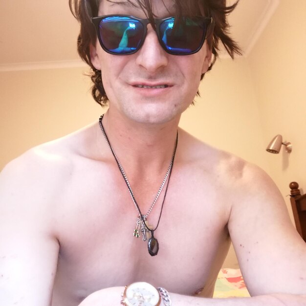 Portrait of shirtless man wearing sunglasses