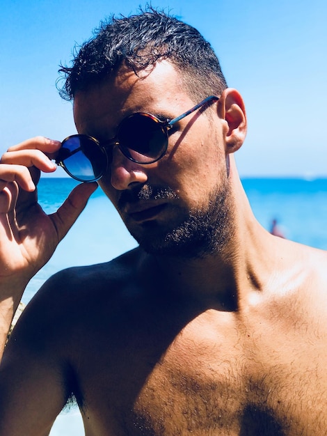 Photo portrait of shirtless man wearing sunglasses