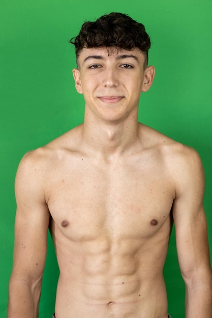 Photo portrait of shirtless young man against green background