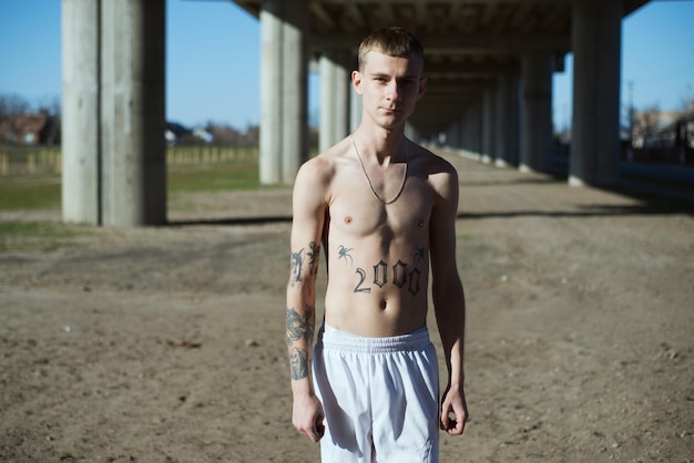 Photo portrait of shirtless young man outdoors