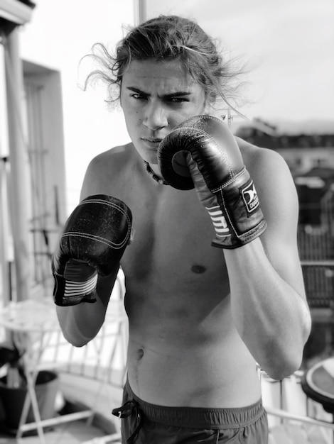 Photo portrait of shirtless young man wearing boxing gloves