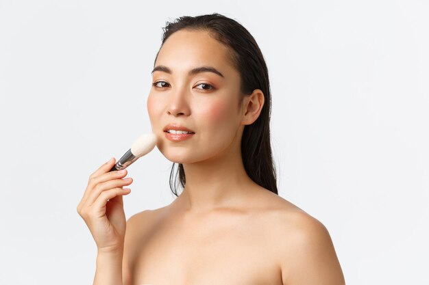 Photo portrait of shirtless young woman against white background