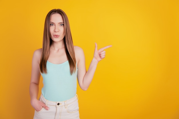 Portrait of shocked amazed lady direct finger blank space open mouth wow expression on yellow background