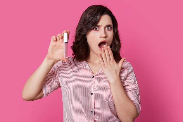 Portrait of shocked dark haired woman with wavy hair