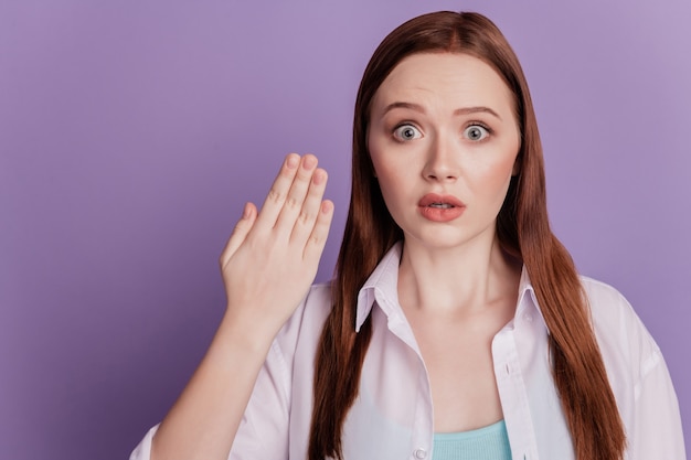 Portrait of shocked stunned lady raise palm staring on purple background