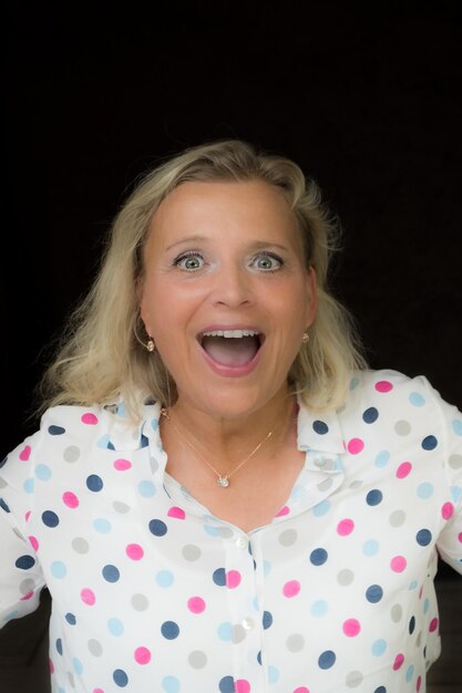 Portrait of shocked woman over black background