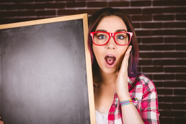 Portrait of shocked woman holding slate