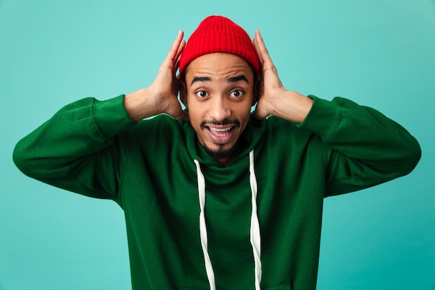 Portrait of a shocked young afro american man in hat