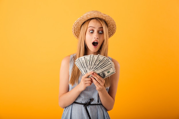 Portrait of a shocked young blonde woman in summer hat