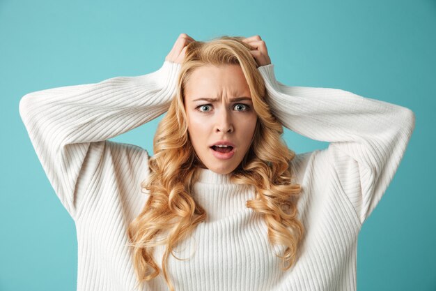 Portrait of a shocked young blonde woman in sweater