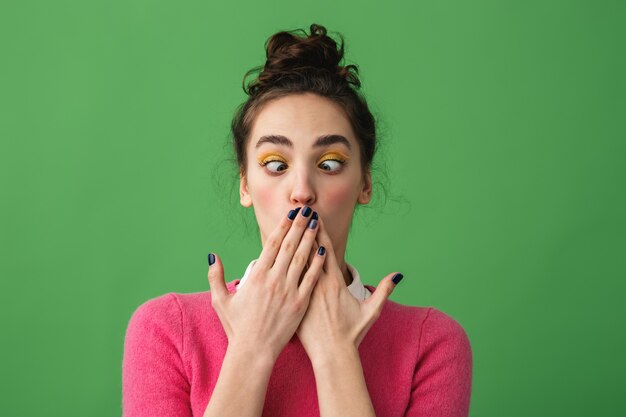 Portrait of a shocked young woman standing isolated