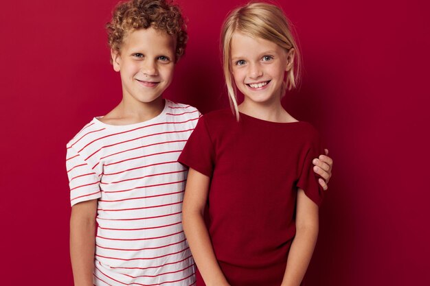 Photo portrait of sibling against red background