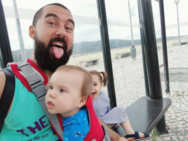 Portrait of siblings with father at bus stop