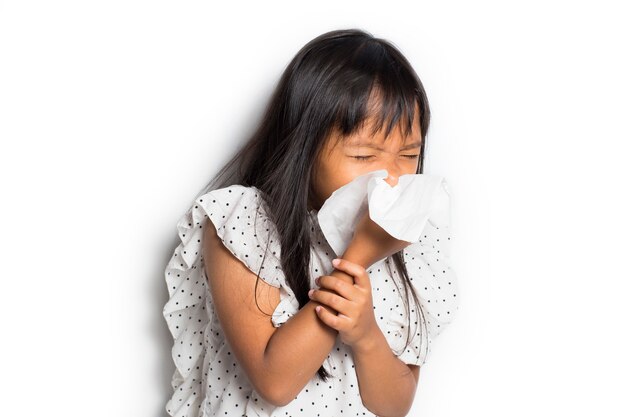 Portrait of Sick asian little child girl wiping and cleaning nose with tissue