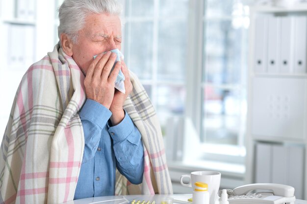 Portrait of a sick elderly man with pills