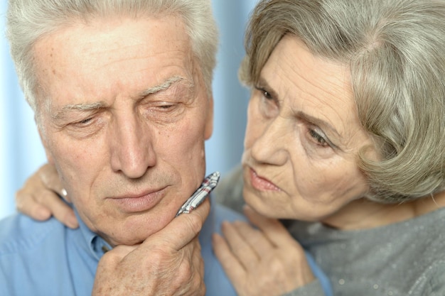 Portrait of sick elderly woman and man at home