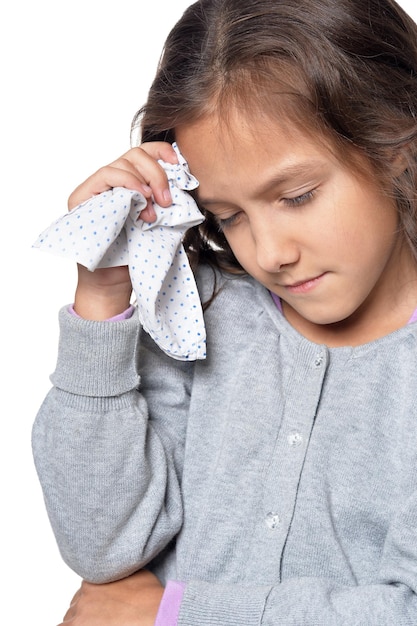 Photo portrait of sick little girl holding handkerchief isolated on white background