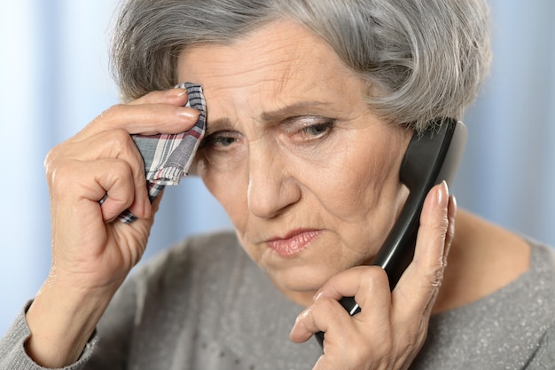 Portrait of a sick mature woman calling doctor