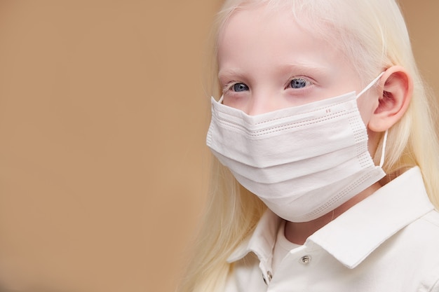 Portrait of sick mystic albino child in medical mask isolated