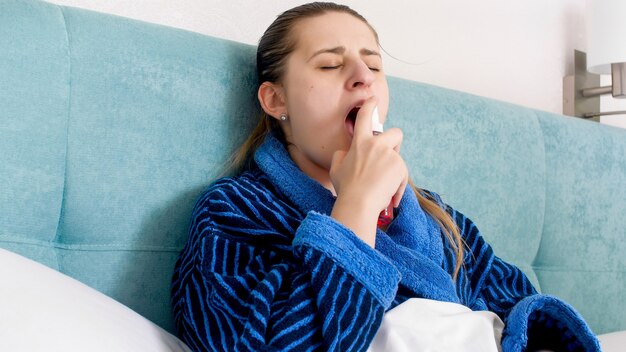 Портрет больной женщины с гриппом, использующей спрей thpat