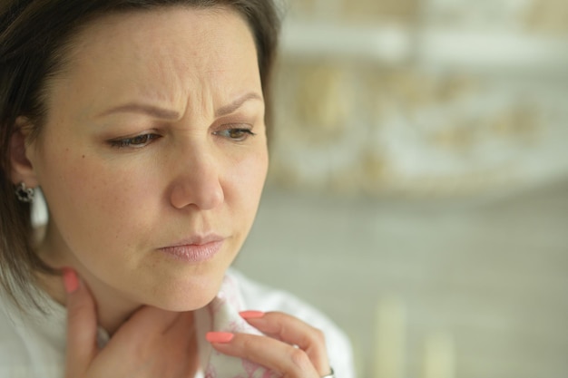 Portrait of sick young woman with sore throat