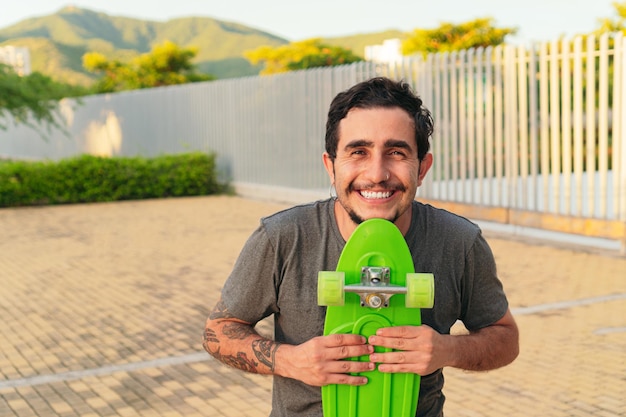 Portrait of a skateboarder smiling in a park