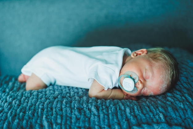 眠っている赤ちゃんの肖像 新生児が眠っている 白い綿のボディスーツを着た赤ちゃん