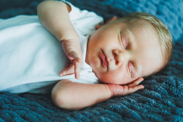 眠っている赤ちゃんの肖像 新生児が眠っている 白い綿のボディスーツを着た赤ちゃん