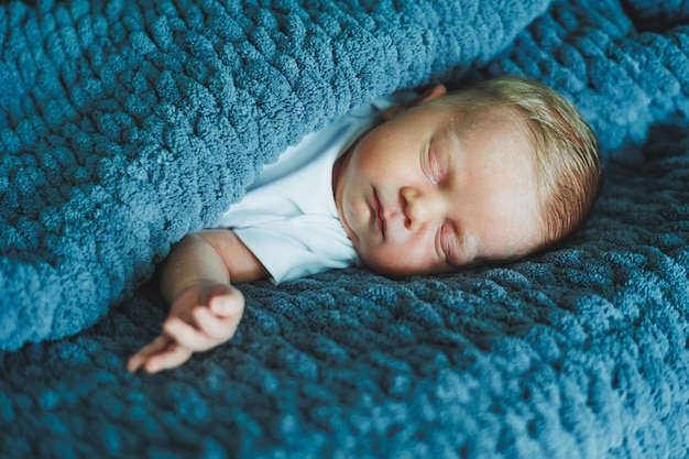 眠っている赤ちゃんの肖像 新生児が眠っている 白い綿のボディスーツを着た赤ちゃん