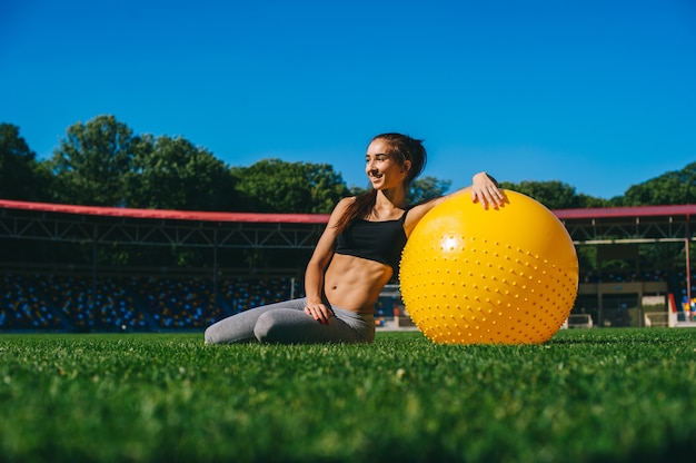 Портрет тонкой женщины, делая упражнения на fitball