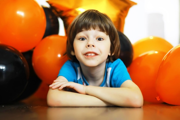 Portrait of a small child lying on the floor in a room decorated with balloons Happy childhood concept