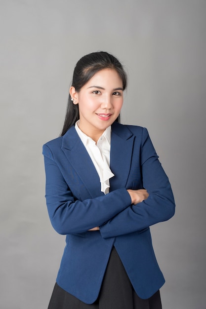 Portrait of smart  business woman in blue suit on grey background, studio shot 