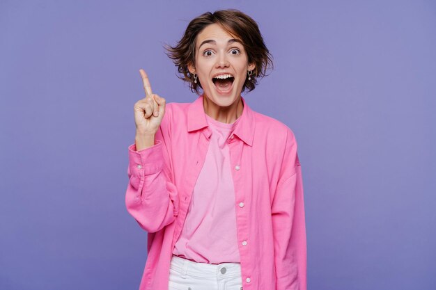 Portrait of smart excited school woman holding finger up having idea looking at camera