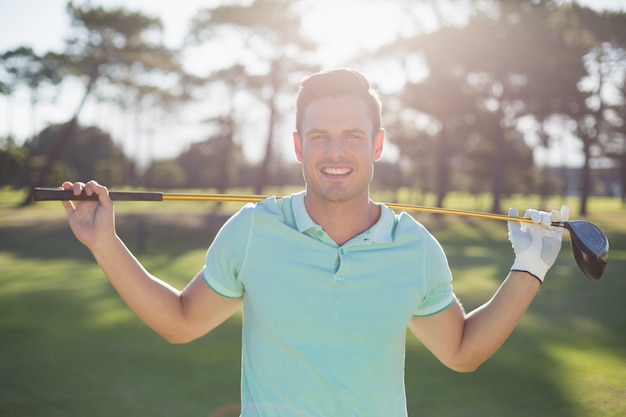 Portrait of smart man carrying golf club