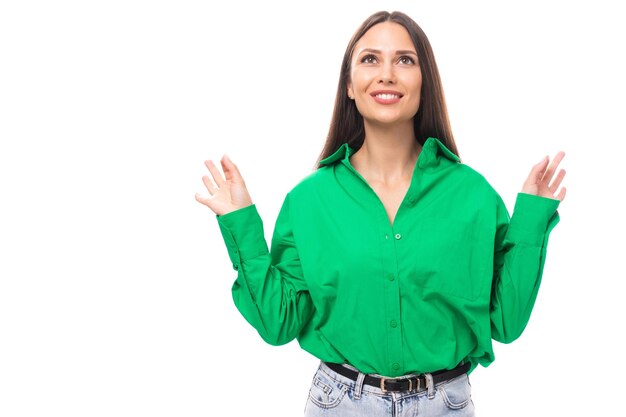 portrait of a smart pensive slim cute browneyed brunette woman dressed in a green shirt smiling on a white background with copy space