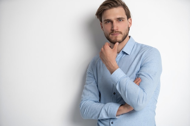 Portrait of a smart young man standing against white background.